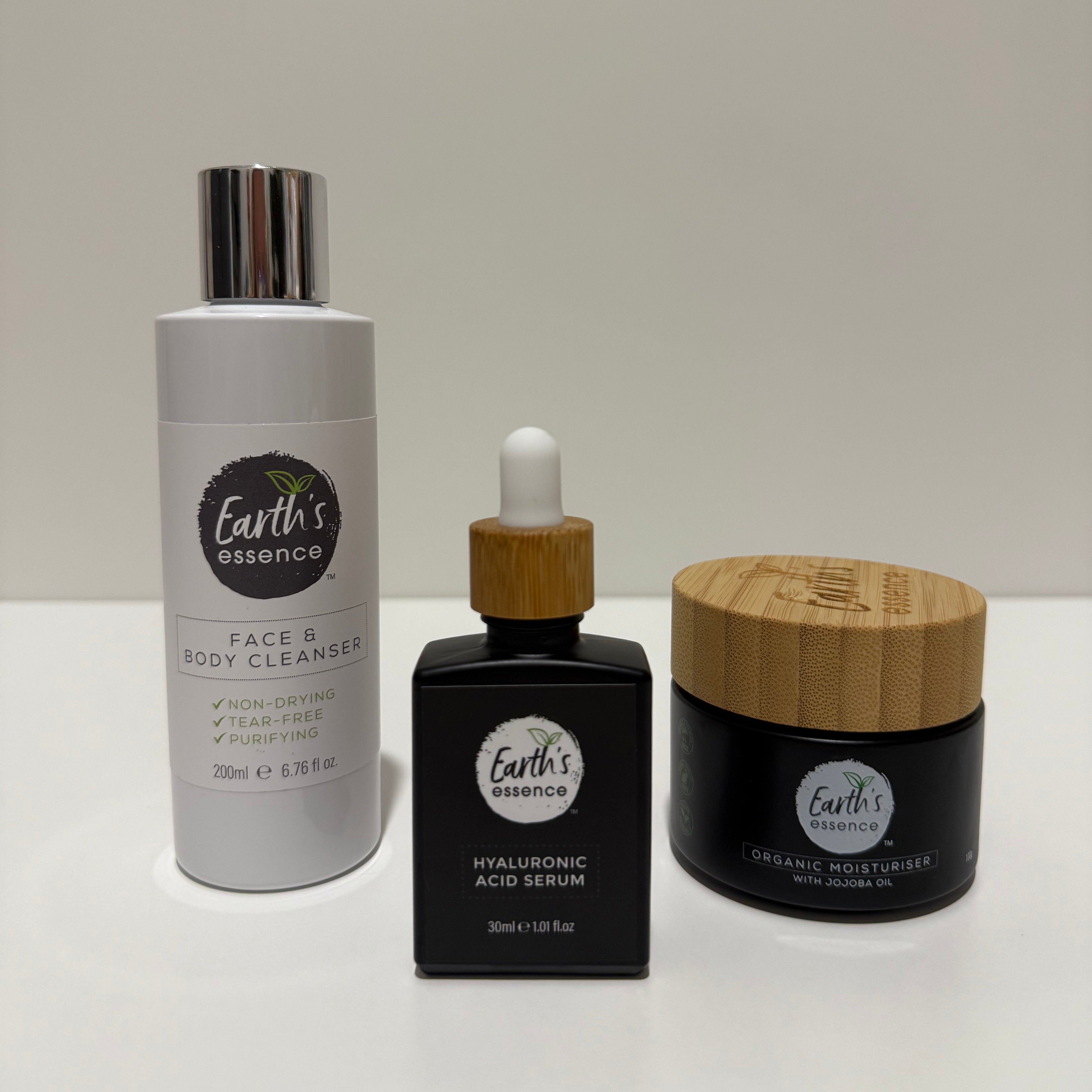 Three Earth's Essentials skincare products on a white surface with a light gray background